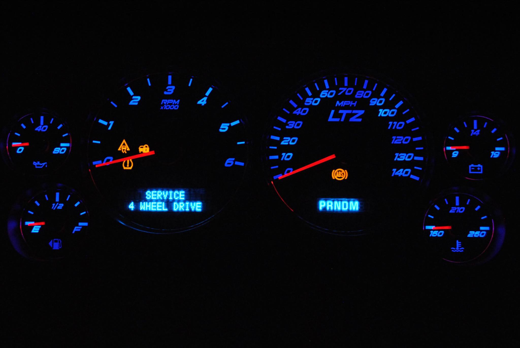 blue LED lights and red needles on a speedometer